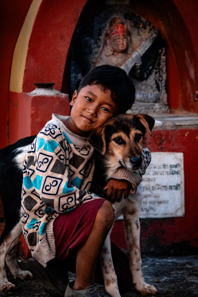 Boy hugging dog.